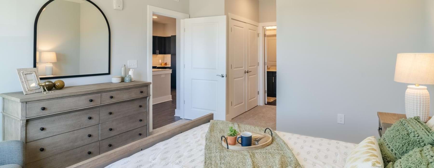 a bedroom with a bed, dresser and a mirror