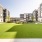 Lush green lawn in center of community with cornhole boards