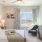 Model bedroom at our senior living apartments in Buford, GA, featuring carpeted flooring and windows with curtains
