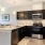 Model kitchen at our senior living apartments in Buford, GA, featuring wood grain flooring and stainless steel appliances